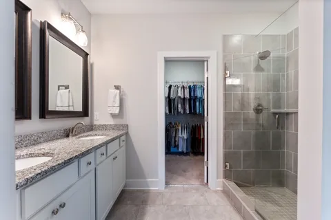 a bathroom with a granite countertop sink a mirror and shower