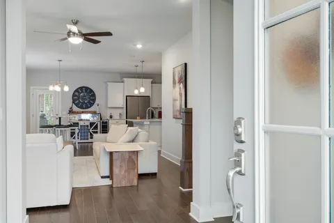 a living room with furniture a ceiling fan and a wooden floor
