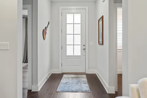 a view of hallway with window and hardwood floor