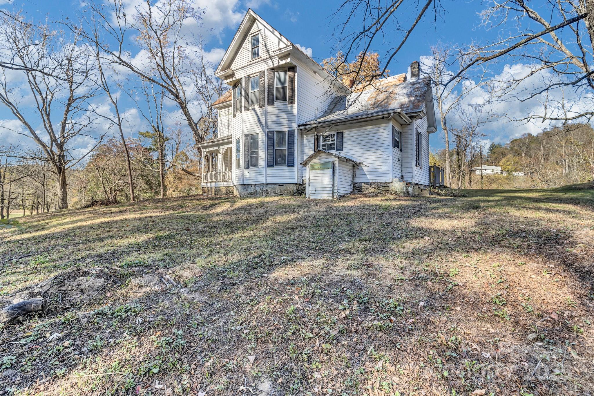 143 Sharon Road Fairview, NC 28730 - Photo 2 of 36 a white house that has a tree in front of it