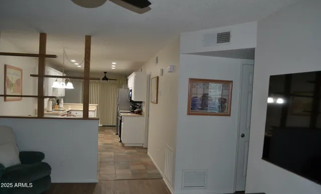 a view of a hallway with stainless steel appliances granite countertop furniture and a fireplace
