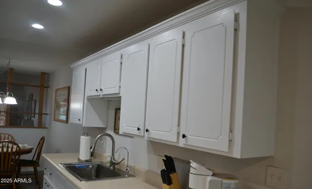 a kitchen with granite countertop white cabinets and sink