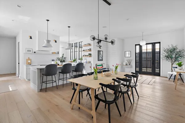 a kitchen with a sink dishwasher stove and white cabinets with wooden floor