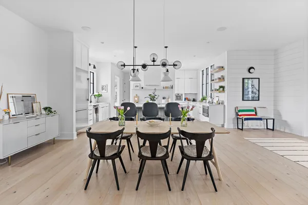 a kitchen with stainless steel appliances granite countertop a sink a stove a refrigerator and island with wooden floor