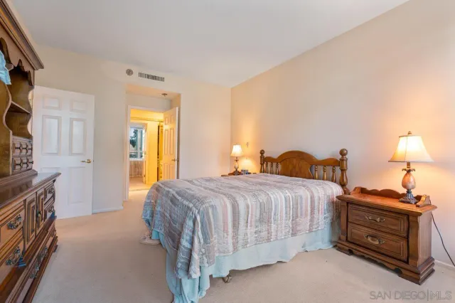 a bedroom with a bed and a flat tv screen on dresser