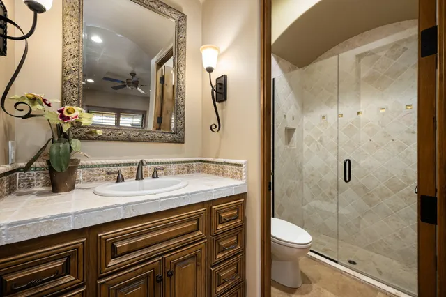 a bathroom with a granite countertop sink toilet and shower