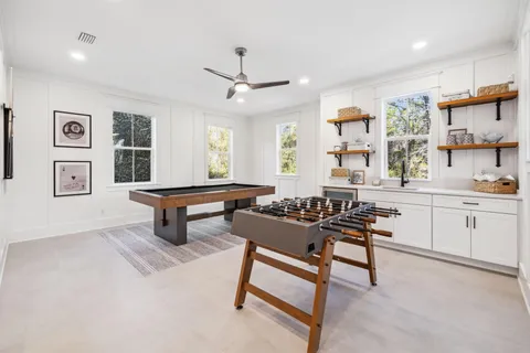 a dining room with wooden floor a chandelier a wooden table and chairs