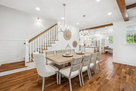 a living room with furniture a clock on wall and a window