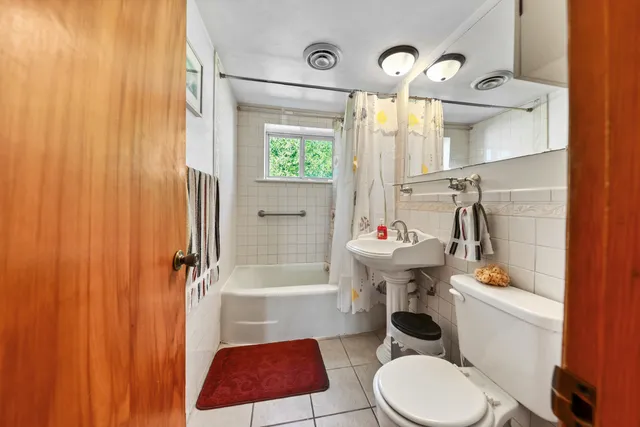 a living room with furniture a flat screen tv and a floor to ceiling window
