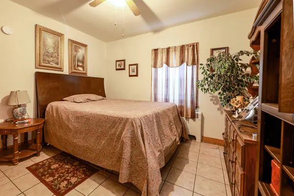 a bed sitting in a bedroom next to a window with potted plants