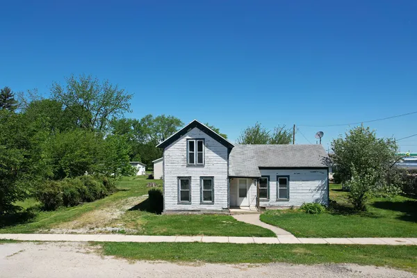 a view of a house with a big yard and large trees