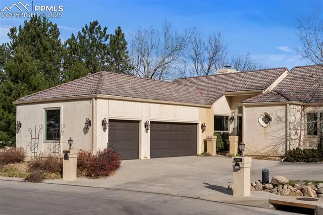 a front view of a house with trees and plants