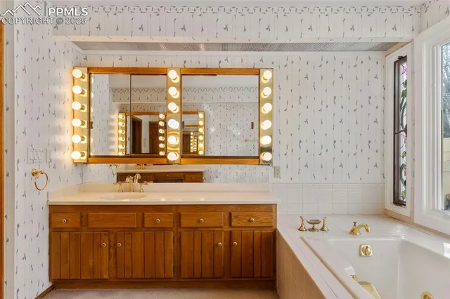 a bathroom with a tub sink and mirror