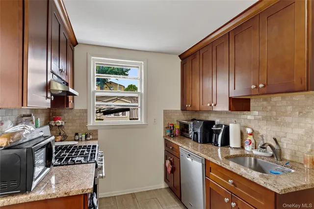 a kitchen with stainless steel appliances a sink a stove a microwave a dining table and chairs