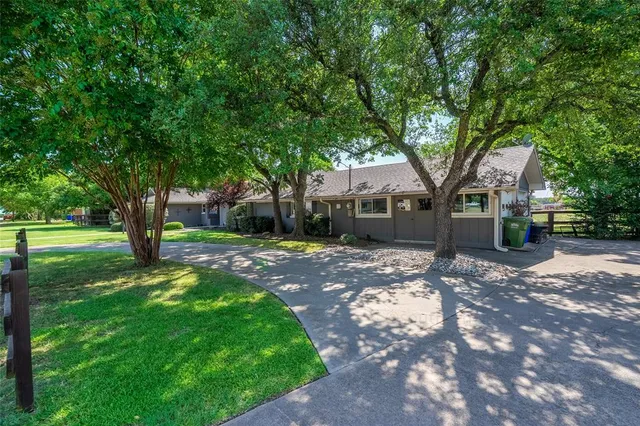 a front view of a house with a yard and tree