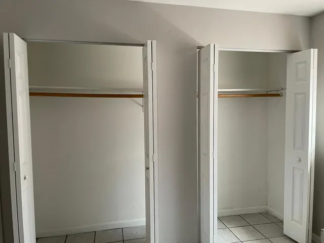 a view of walk in closet with empty racks