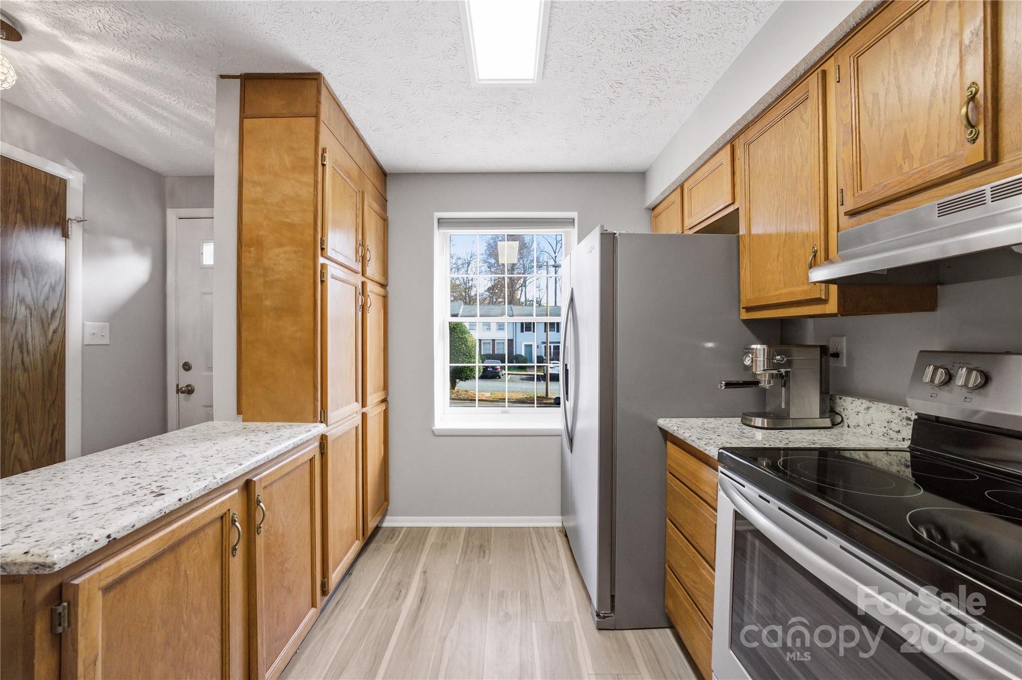 1235 Scaleybark Road, Unit C Charlotte, NC 28209 - Photo 4 of 33 a kitchen with granite countertop a sink a stove and refrigerator