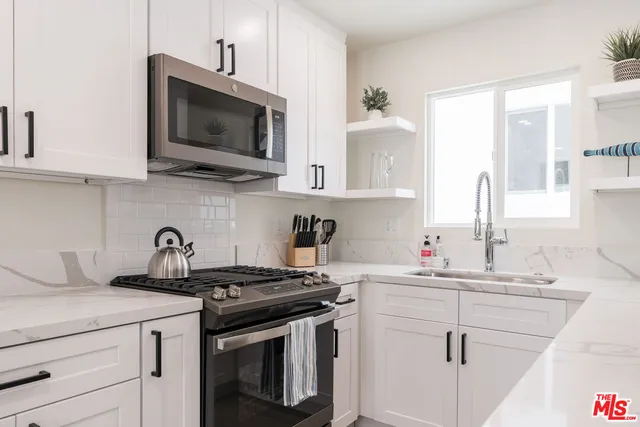 a kitchen with stainless steel appliances a sink a stove and microwave