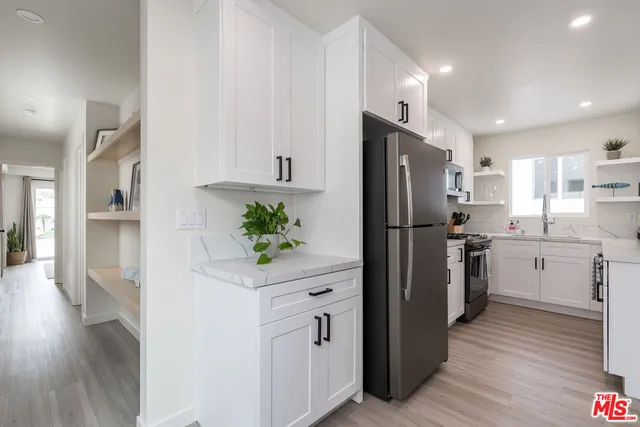 a kitchen with white cabinets and stainless steel appliances
