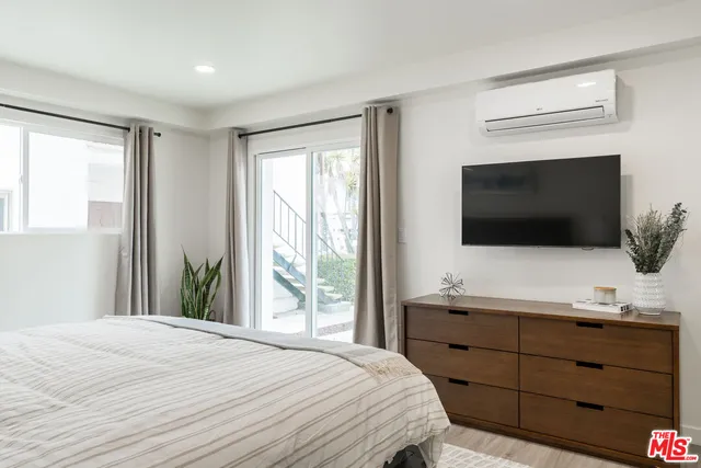 a bedroom with a bed and a flat screen tv