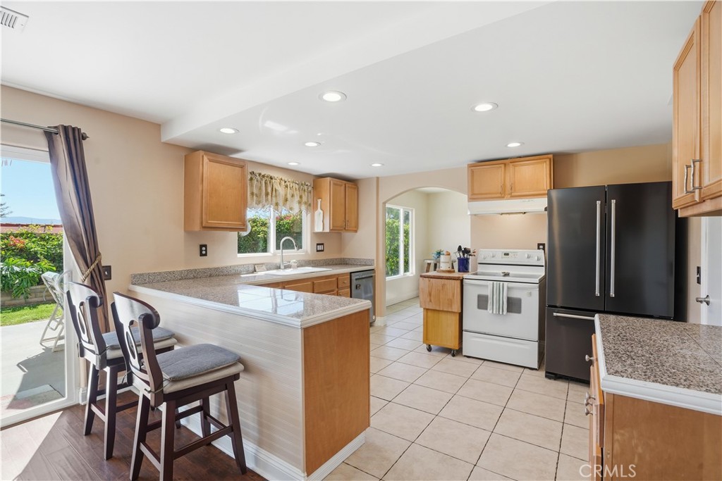 3330 Township Avenue Simi Valley, CA 93063 - Photo 11 of 40 a kitchen with a table chairs refrigerator and microwave