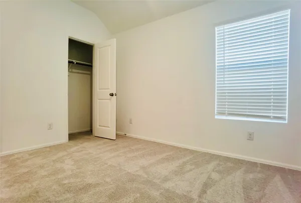 an empty room with a window and a bathroom