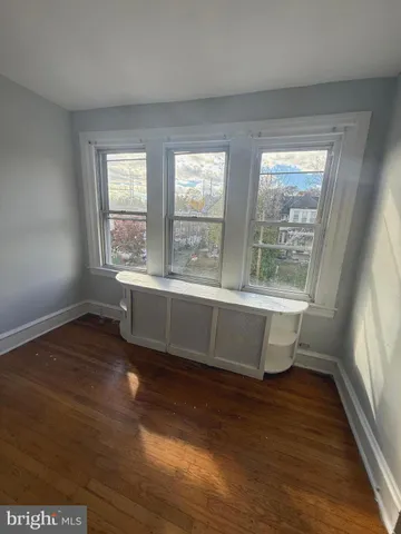 a view of a room with wooden floor and a window