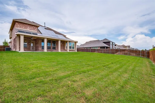 a view of a house with a big yard and large trees