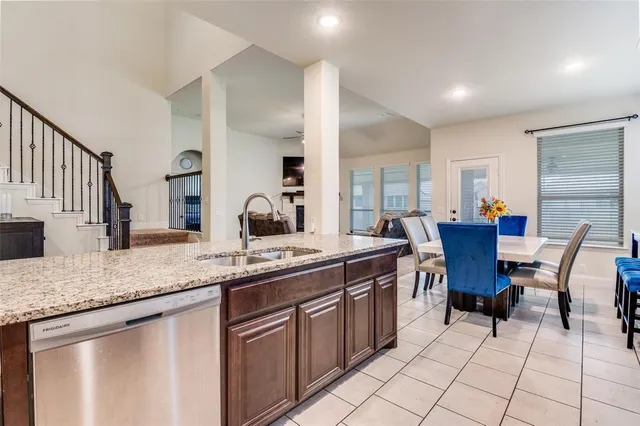 a kitchen with a sink and chairs