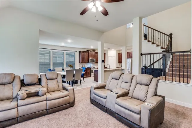 a living room with furniture ceiling fan and a rug