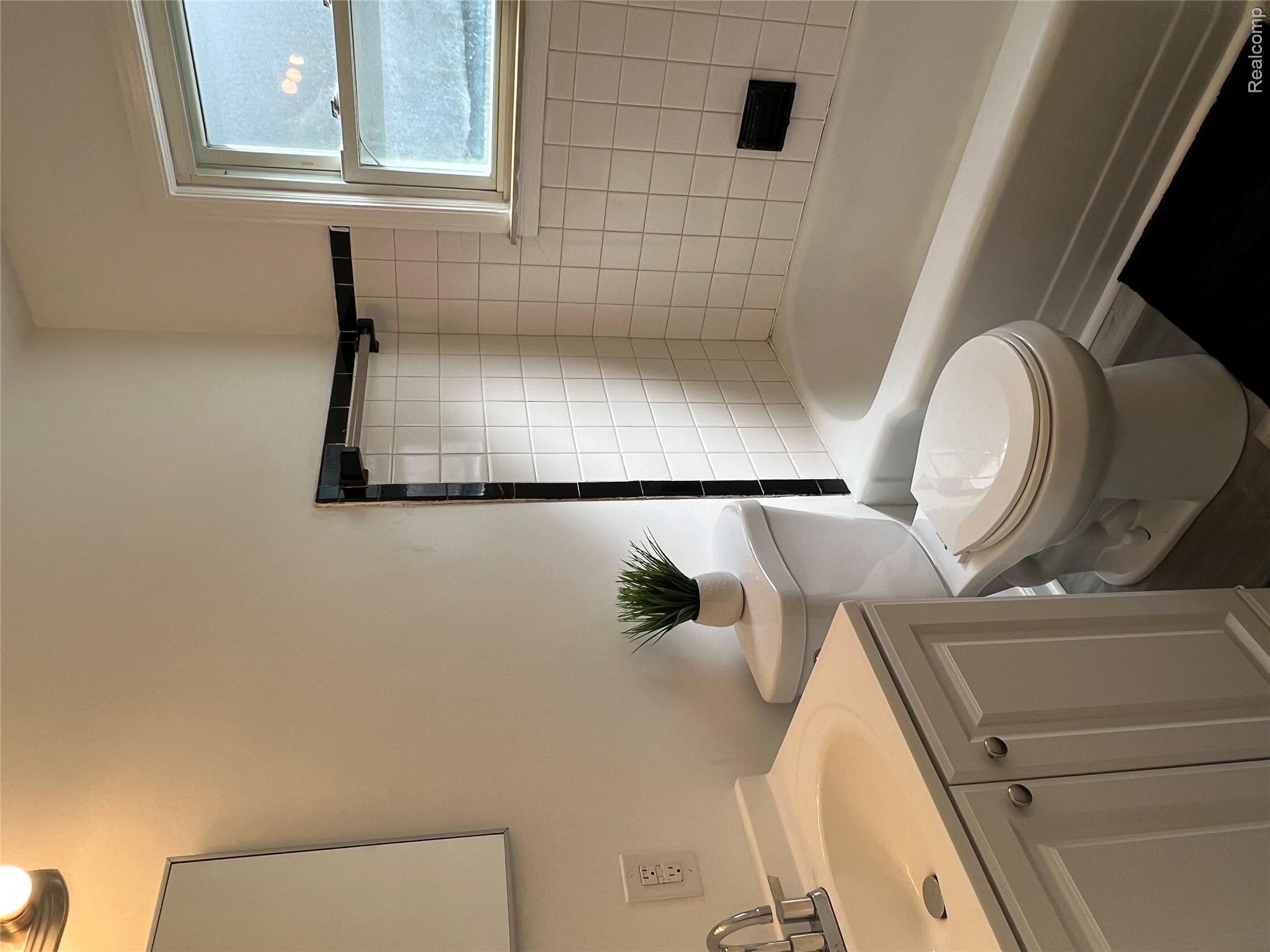 4034 Fleming Road Flint, MI 48504 - Photo 13 of 20 White vanity with integrated sink, chrome faucet, and panel-front cabinetry