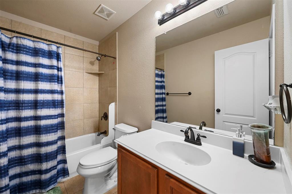 14815 Frisco Ranch Drive Little Elm, TX 75068 - Photo 28 of 40 a bathroom with a sink a toilet a mirror and shower curtain