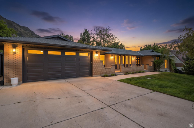 4150 Dover Lane Provo, UT 84604 - Photo 1 of 44 Brick exterior featuring a multi-panel garage door with transom windows, a concrete driveway, and front landscaping