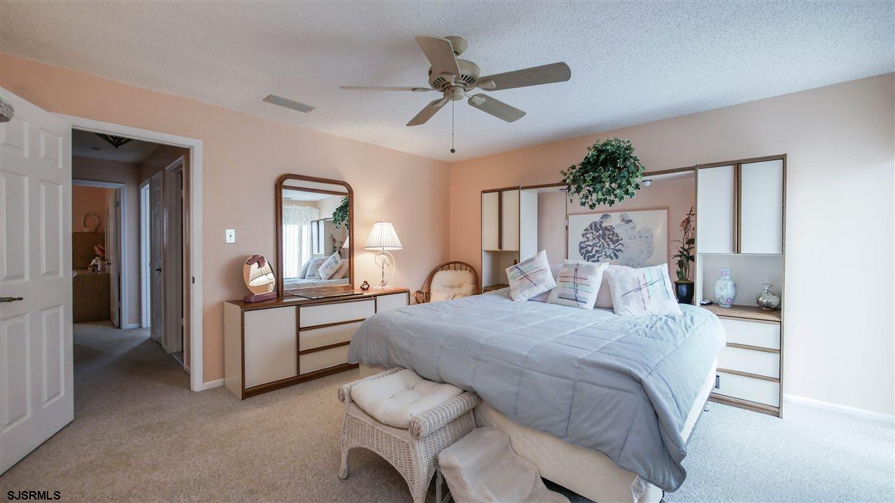 11 Sailfish Drive Brigantine, NJ 08203 - Photo 14 of 23 a bedroom with a bed and a chandelier