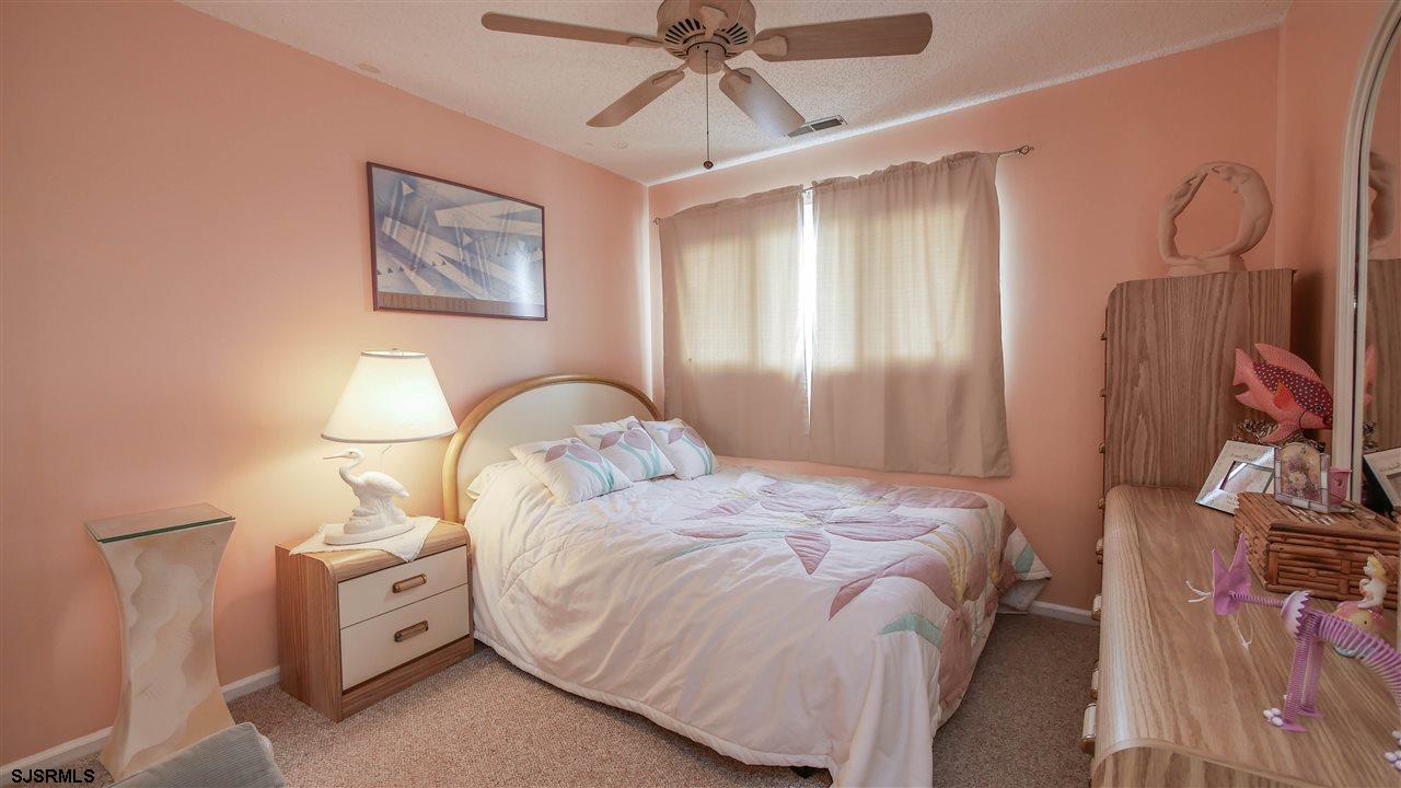 11 Sailfish Drive Brigantine, NJ 08203 - Photo 19 of 23 a bedroom with a bed and a chandelier