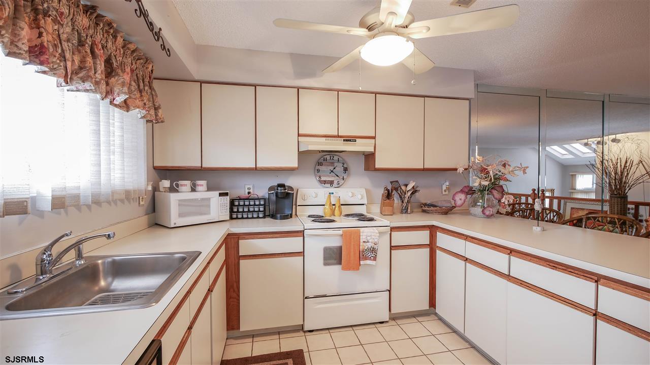 11 Sailfish Drive Brigantine, NJ 08203 - Photo 6 of 23 a kitchen with kitchen island granite countertop a sink a counter top space appliances and cabinets