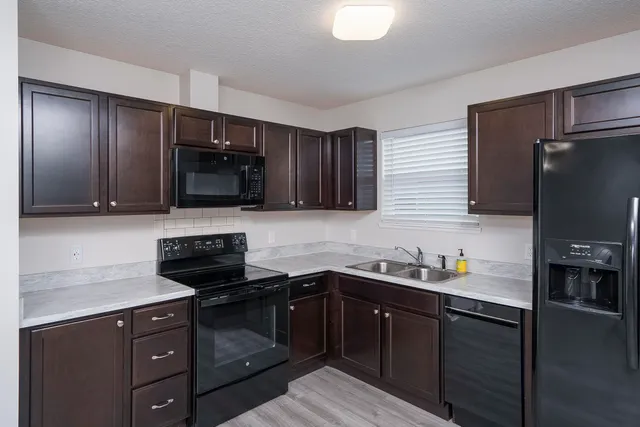 a kitchen with stainless steel appliances granite countertop a sink stove and refrigerator