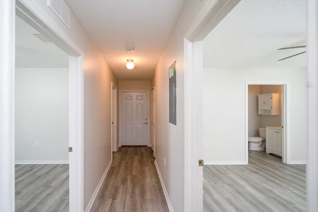 a view of a room with wooden floor and a bathroom