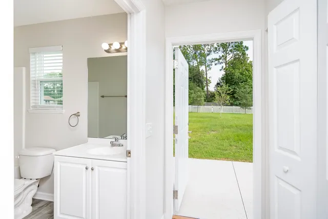 a bathroom with a sink a toilet a large mirror and a window