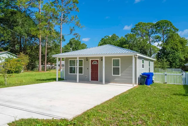 a view of a house with a yard and potted plants
