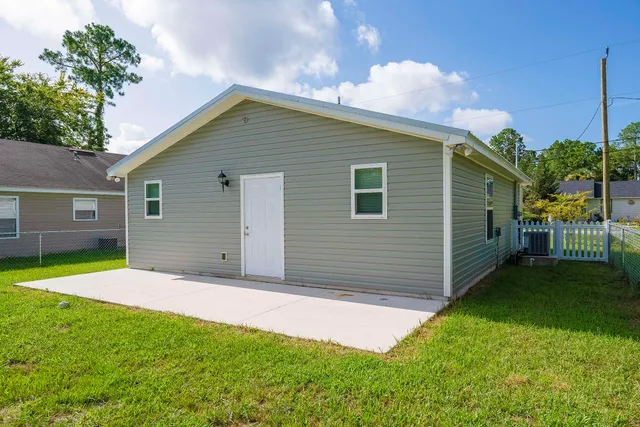 a backyard of a house with barbeque oven and table and chairs