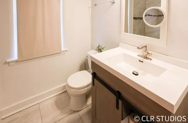 a bathroom with a sink a toilet and a mirror
