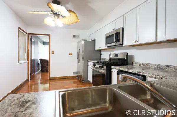a kitchen with stainless steel appliances granite countertop a sink and a stove