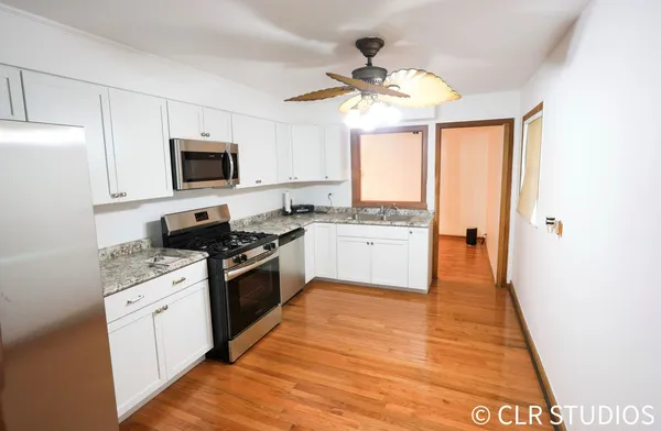 a kitchen with a sink appliances cabinets and a window