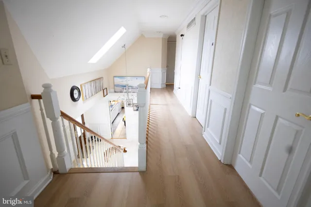 a view of a hallway with wooden floor and stairs