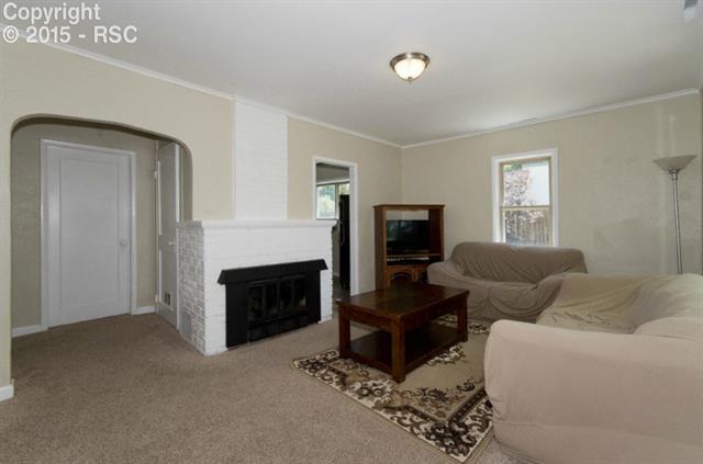 615 Sunset Road Colorado Springs, CO 80909 - Photo 4 of 20 Living room features wood burning fireplace.