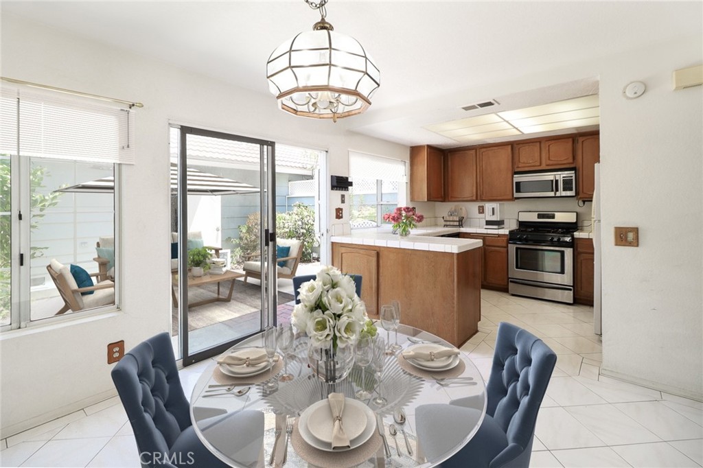 345 Jeremiah Drive, Unit C Simi Valley, CA 93065 - Photo 4 of 66 a dining room with stainless steel appliances kitchen island granite countertop a kitchen island a table and chairs