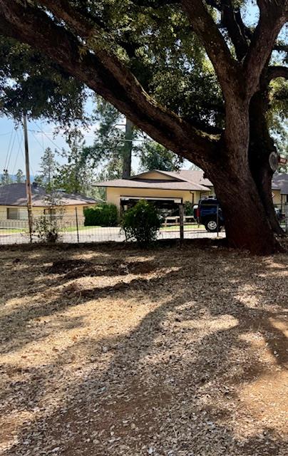 a view of a yard with wooden fence