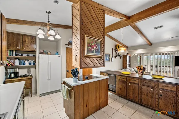 a kitchen with sink a refrigerator and wooden cabinets