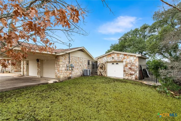 a view of a house with a big yard and large tree